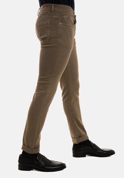 Pantaloni slim-fit color khaki realizzati in una miscela di cotone, con cinque tasche e orli arrotolati, abbinati a mocassini neri per un look formale.