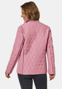 Gequilted roze jas met een hoge kraag, voorzien van een ruitpatroon en contrasterende stiksels. Gladde stof met zijzakken.