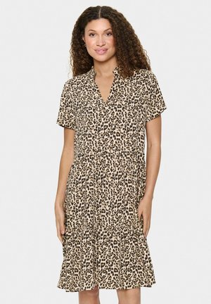 Leopardmönstrad klänning med korta ärmar, v-ringning och lagerad kjol. Tillverkad av lättviktig textil, med en beige bas och svarta fläckar.