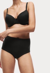 Set di biancheria intima nera composto da un reggiseno imbottito con spalline regolabili e mutandine seamless a vita alta. Tessuto liscio e elastico.