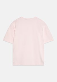 T-shirt à manches courtes, col rond, en coton rose doux. Présente un design uni avec une coupe relaxée et un ourlet standard. Pas de logos ni de motifs visibles.