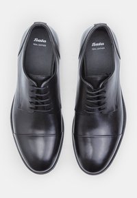 Scarpe nere in pelle con finitura liscia, punta rotonda e tacco basso. Presentano un classico design con lacci e dettagli di cucitura visibili.