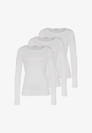 Trois chemises blanches unies identiques à manches longues et col rond, soigneusement empilées avec un léger chevauchement sur un fond blanc.