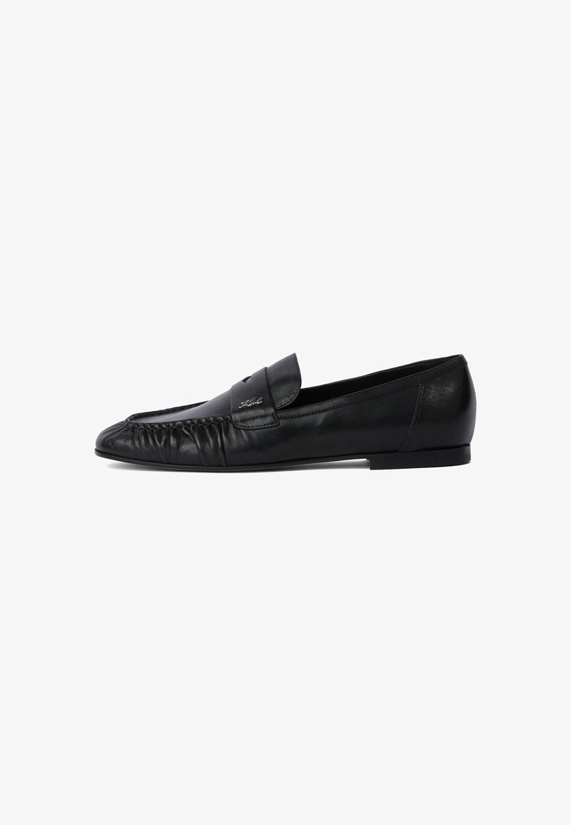 Black leather loafers with a rounded toe, stitched detailing on the front, and a flat sole. Minimalist design with a subtle logo accent.