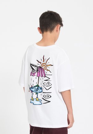 Ragazzo con maglietta bianca con una grafica colorata di pesci sotto un ombrello rosa, sole, gocce di pioggia e testo "VOLCOM" sul retro.