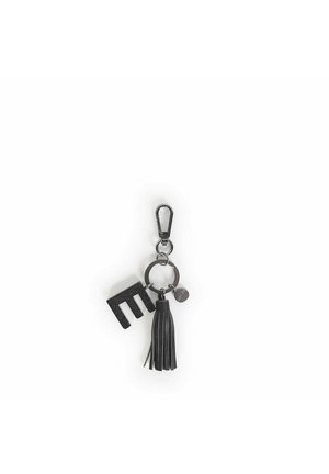 Portachiavi nero con una lettera "M" testurizzata, un ponpon in pelle e un cerchio metallico con un charm a forma di logo. Caratterizzato da un moschettone per il fissaggio.