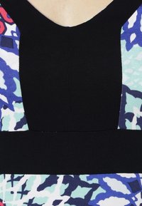 Värikäs, kuvioitu kangasmekko mustalla rinnuksella ja sekoitetuilla kuvioilla, joissa on sinistä, vihreää ja vaaleanpunaista, sileä rakenne ja muotoiltu malli.