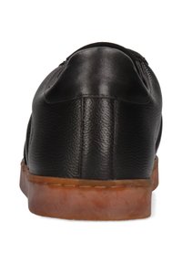 Schwarzer Lederschuh mit niedrigem Profil, abgerundetem Rücken und kontrastierender Gummisohle. Strukturiertes Obermaterial und glatte Oberfläche. Keine sichtbaren Metallteile.