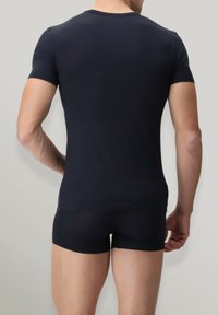 T-shirt aderente di un blu scuro con maniche corte e collo rotondo, abbinato a pantaloni corti aderenti dello stesso colore; realizzato in materiale morbido ed elasticizzato.
