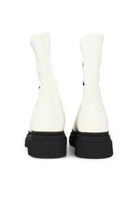 Witte synthetische enkelboots met een gladde textuur, een slank design en zwarte rubberen zolen. De achterkant heeft minimalistische accenten.