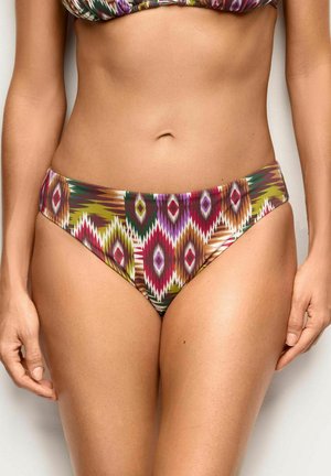 Donna che indossa slip bikini con stampa tribale geometrica colorata, mostrando la zona media e la parte superiore delle cosce su uno sfondo uniforme.