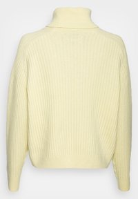 Maglione a collo alto ribbed di color giallo chiaro, con maniche lunghe, dal fit morbido e tessuto testurizzato, ideale per essere indossato a strati nelle giornate più fresche.