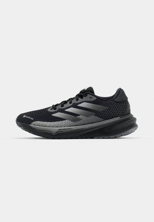 Schwarzer Laufschuh mit strukturiertem Obermaterial, metallic-grauen Akzenten und einer dicken Zwischensohle mit einzigartigem Profil. Leicht und atmungsaktiv im Design.