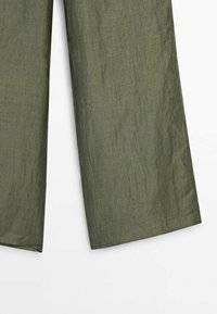 Pantalon large vert olive en tissu léger légèrement texturé présenté sur fond blanc.