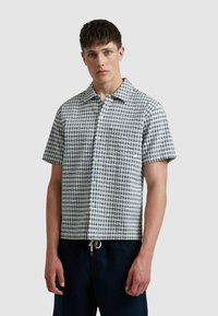 Korte mouwen overhemd in een blauw-witte blokpatroon, met een knoopsluiting aan de voorkant, een camp collar en een zak op de linker borst.