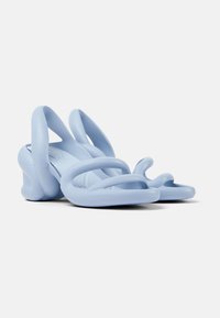 Light blue rubber high-heeled sandals with a unique twisted strap design, smooth texture, and rounded heel for a contemporary look.