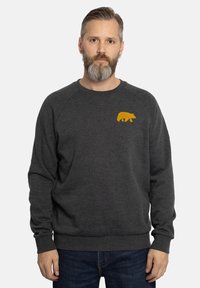 Grijze sweatshirt met een geribbelde halslijn en manchetten, voorzien van een kleine gele beer grafiek op de borst. Zachte textuur, ontspannen pasvorm.