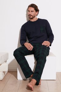 Cămașă albastră închis cu mânecă lungă și buzunar din tartan verde, asortată cu pantaloni din tartan verde. Materialul pare moale; designul are o croială lejeră și picioare drepte.