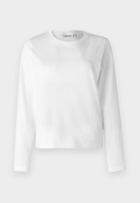 Hvid langærmet t-shirt lavet af bomuld, med rund hals og løs pasform. Designet er enkelt uden synlige mønstre eller dekorationer.