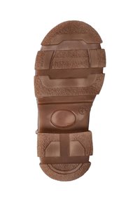 Bruine rubberen schoenzool met gestructureerde patronen, indeukingen en een cirkelvormig logo met het nummer 25 aan de zijkant.