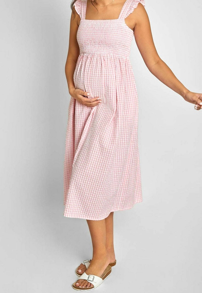 Rosa rutigt midiklänning med fyrkantig halsringning, rynkad bodice och volangremmar; bärs med vita sandaler med platt sula och en avslappnad passform.