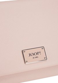 Roza teksturirana denarnica z metalno srebrno ploščico z napisom "JOOP! JEANS" in štirimi zakovicami, ki ima zložljiv dizajn.