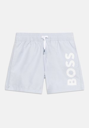 Jasnoniebieskie spodenki kąpielowe z elastyczną talią, białym sznurkiem, bocznymi kieszeniami oraz dużym pionowym białym logo "BOSS" na prawej nodze.