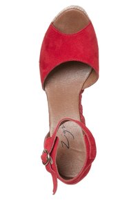 Chaussure ouverte en suède rouge avec une sangle à la cheville arborant une boucle en argent, semelle intérieure en cuir lisse, et détails en jute de style espadrille sur le talon.