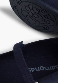 Granatowe buty z materiału z gładką teksturą, z paskiem i czarną gumową podeszwą z detalami w kwiatowy wzór.