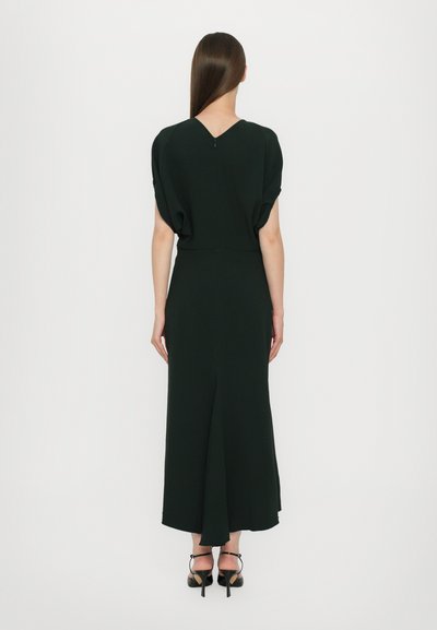 Vestido negro midi con un escote en V en la espalda y mangas cortas y abullonadas. La tela es suave, presenta una sutil textura y una abertura en la parte posterior central.