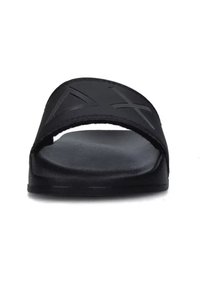 Infradito neri con una larga fascia caratterizzata da design geometrici intagliati. Texture liscia con suola piatta in gomma, che enfatizza comfort e stabilità.