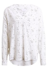 Blusa blanca de manga larga con escote en V, con estampado de estrellas negras. Tejido suave, corte holgado y dobladillo ligeramente redondeado.