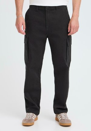 Black cotton cargo pants featuring two side pockets, straight leg design, and a button closure. Worn with gray sneakers.