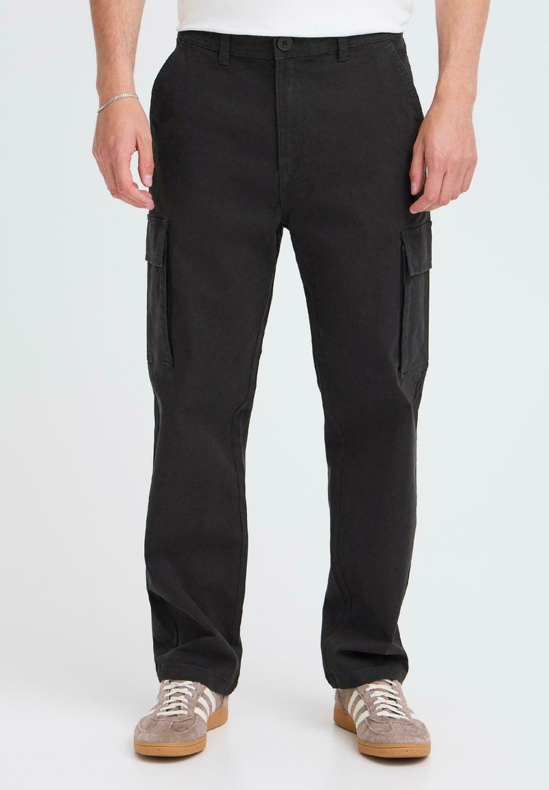 Black cotton cargo pants featuring two side pockets, straight leg design, and a button closure. Worn with gray sneakers.