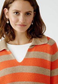 Gestreifter Pullover in Orange und Beige, mit V-Ausschnitt und umklappbarem Kragen, aus geripptem Strickstoff gefertigt.