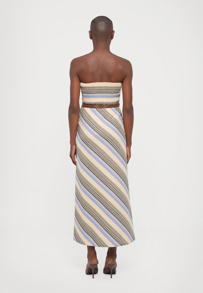 Randig tvådelad outfit bestående av en smockad crop top och en maxi kjol, med horisontella ränder i beige, blå och grå nyanser.