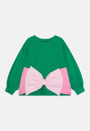 Sudadera verde de manga larga con una parte inferior rosa y un gran lazo rosa texturizado en la cintura. Cuello redondo y mangas con puños.