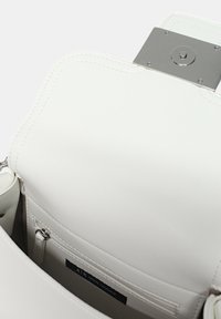 Borsa a tracolla bianca in pelle con texture liscia, dotata di una chiusura metallica argentata e di una tasca interna con zip. Etichetta visibile all'interno.