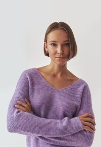 Lila Strickpullover mit V-Ausschnitt, langen Ärmeln und einer weichen Textur mit einem subtilen vertikalen Muster.