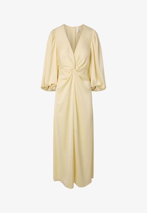 Duga blijedožuta haljina s dubokim V-izrezom, uvijenim prednjim detaljem, napuhanim rukavima tri četvrt te lagano skupljenim strukom.