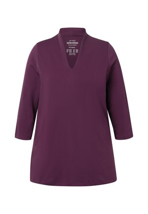 Tunic viola con scollatura a V e maniche a tre quarti. Realizzata in un tessuto morbido, presenta una vestibilità comoda e una texture liscia.