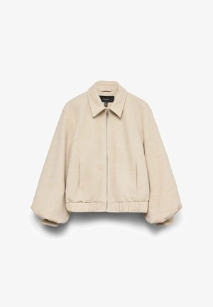 Beige cropped jakke med løs pasform, der har en lynlås foran, vide ærmer og en spids krave. Blødt stof.