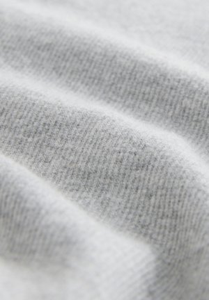 Svetlosivá látka s textúrovaným, rebrovaným vzorom; mäkký a jemne chlpatý povrch, zobrazujúci hladké, plynulé záhyby.