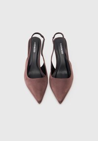 Sandaletas de camurça castanha com um design de bico fino. Apresenta uma tira fina e uma palmilha preta suave. Forma minimalista e elegante.