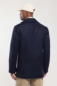 Abrigo de mezcla de lana en color marino con un corte entallado, cuello con muescas y una abertura trasera sencilla. Presenta mangas largas y un sutil acento de marca en el hombro.