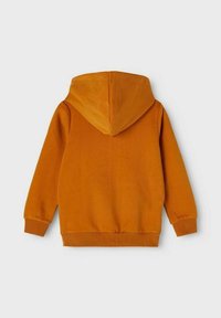 Sweatshirt à capuche de couleur orange vif, fabriqué en tissu doux, avec un ourlet et des poignets côtelés, présentant une grande capuche à l'arrière et un design sans coutures.