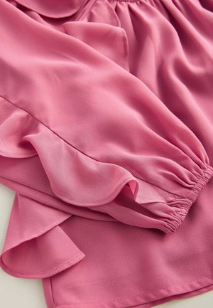 Rosa Bluse aus leichtem Stoff, mit Rüschenschultern und einem elastischen Taillenbund, in glatter Textur und fließendem Design.