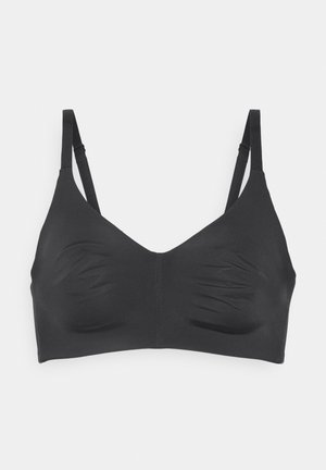 Reggiseno wireless nero senza cuciture con spalline sottili regolabili, coppe sagomate e finitura liscia, mostrato su uno sfondo bianco uniforme.