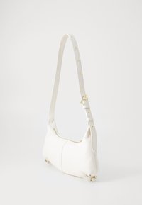 Sac à épaule en cuir blanc avec une finition texturée, forme courbée, accents en métal doré et une bandoulière détachable et ajustable.