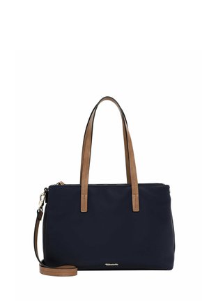 Navy blue tote bag with brown leather handles, zip closure, and adjustable shoulder strap. Smooth texture, minimalist design, and logo detail.